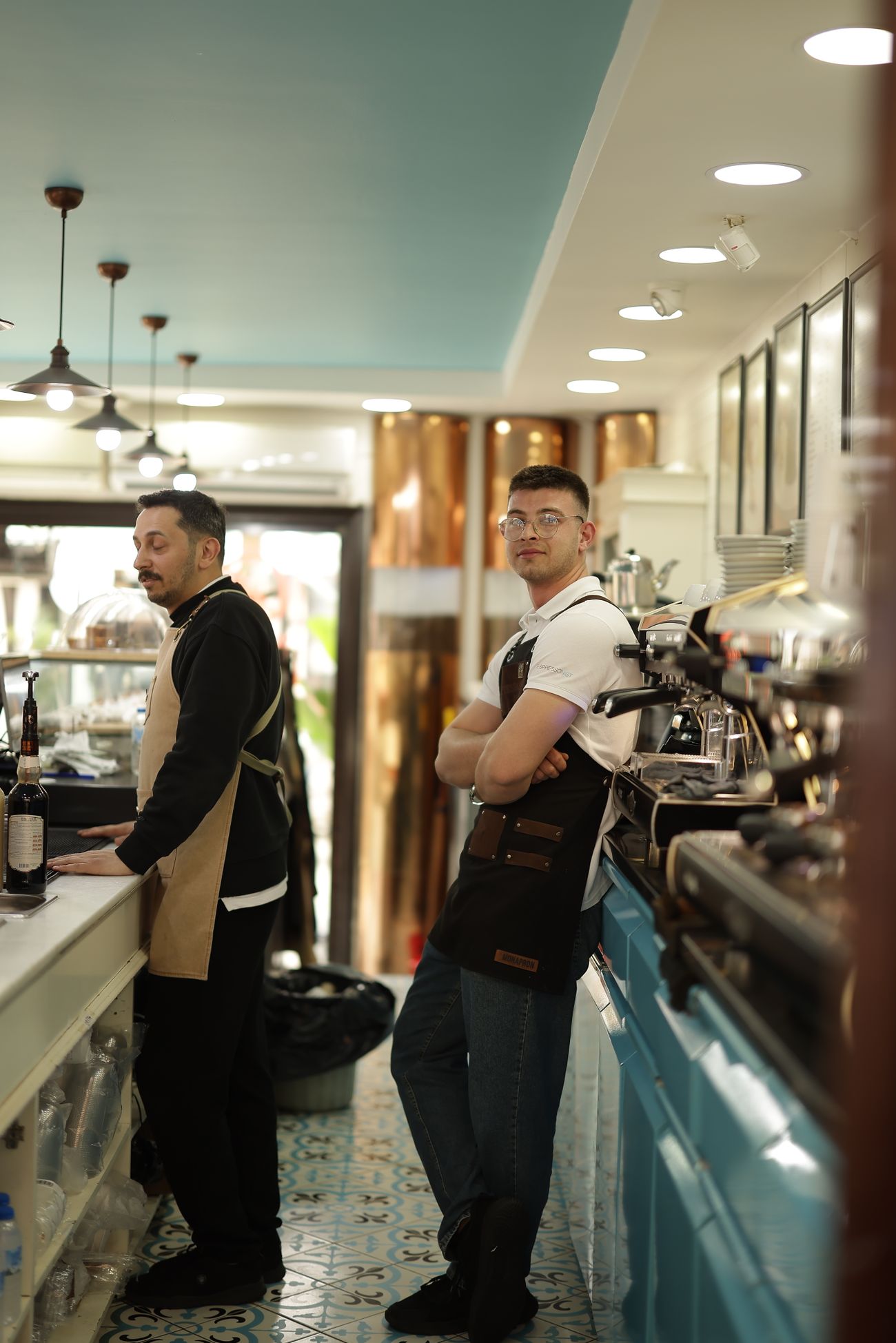 Baristas behind the counter of a modern cafe ready for service