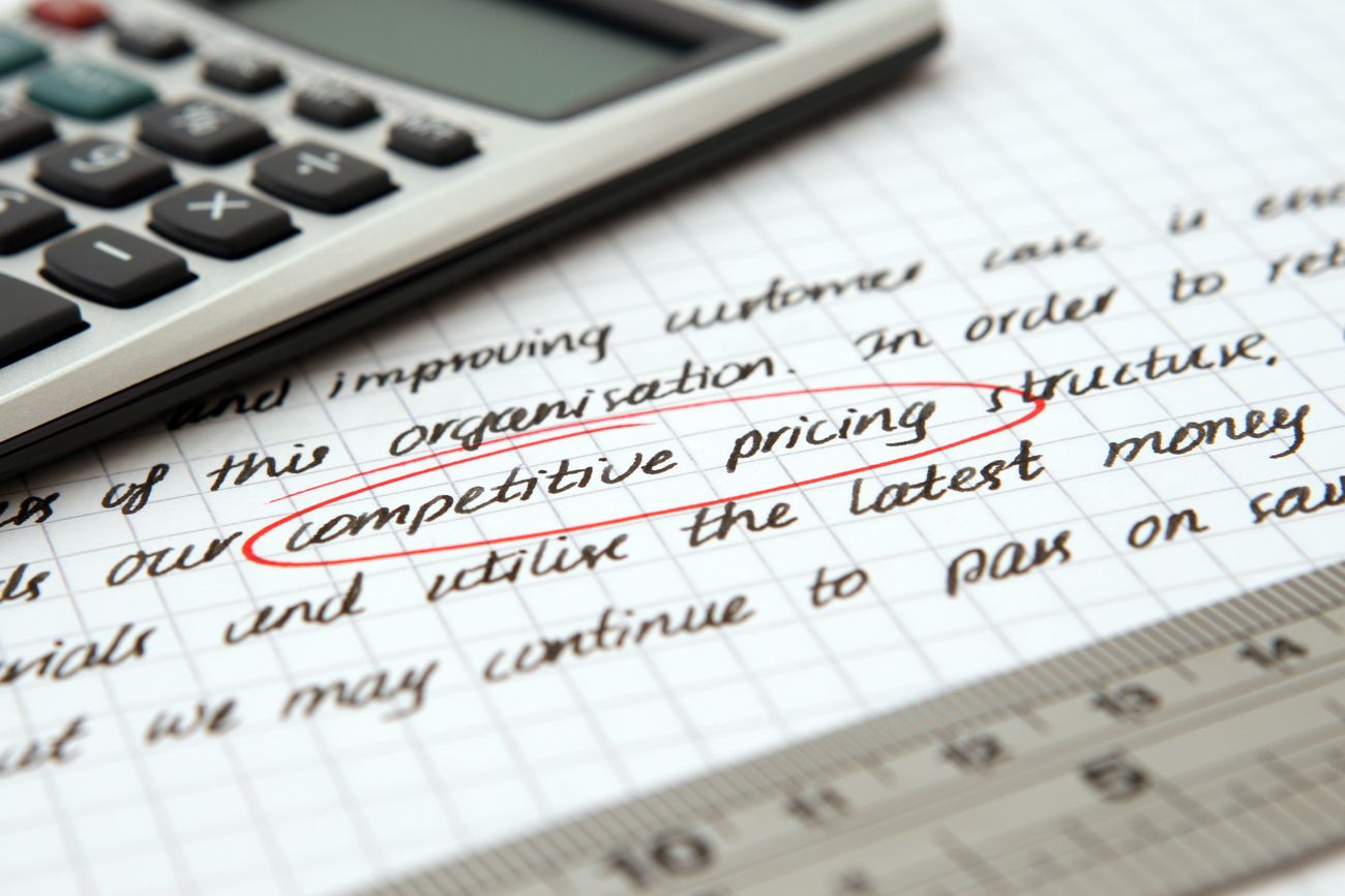 Handwritten pricing calculations beside a calculator during a pricing strategy review